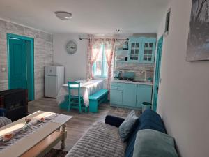 a living room with a blue couch and a kitchen at Šumarac in Karadak