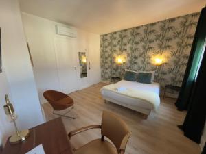 a bedroom with a bed and a table and chairs at Aux Vendanges de Bourgogne in Paray-le-Monial