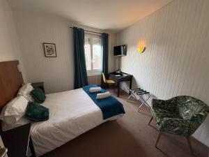 a hotel room with a bed and a chair at Aux Vendanges de Bourgogne in Paray-le-Monial +185 photos