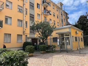 a large yellow building with a tree in front of it at AfforiCentro in Milan