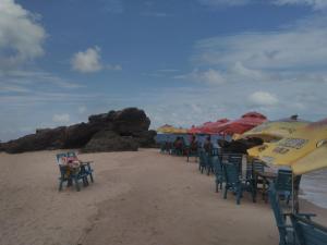 una fila de sillas y sombrillas en una playa en Pousada Sossego Ronaldo e Clarinha, en Alter do Chao