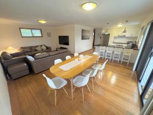 a living room and kitchen with a table and chairs at Beside the Seaside Gerroa Dual Family Living in Gerroa