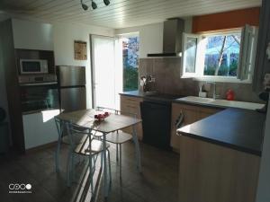 een keuken met een kleine tafel en stoelen. bij Castorette, au calme, petit déjeuner compris in Mimizan