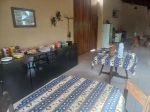 a kitchen with a counter and a table and a chair at Pousada Rural Veredas in Piancó