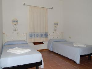 a room with two beds and a window at Residence Spiaggia Bianca in Golfo Aranci