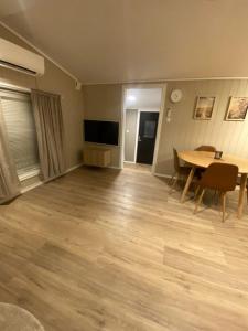 an empty living room with a table and a television at Furnishe outhouse in Bergen
