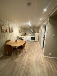 a kitchen and dining room with a table and chairs at Furnishe outhouse in Bergen