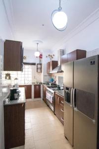 a kitchen with a stainless steel refrigerator and wooden cabinets at Suitehub in Ikeja