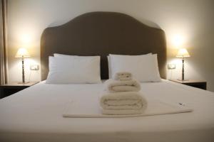 A bed or beds in a room at Hotel Hermes Tirana