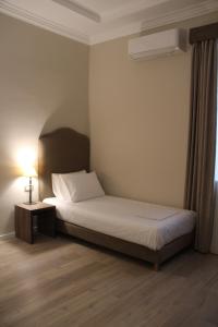 A bed or beds in a room at Hotel Hermes Tirana