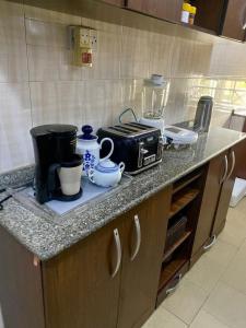 a kitchen counter with a toaster and pots and pans at Suitehub in Ikeja +4 photos