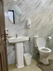 a bathroom with a sink and a toilet and a mirror at Suitehub in Ikeja