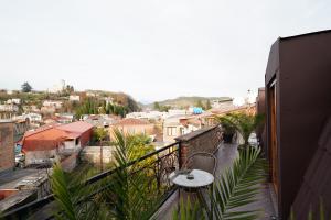 a balcony with a table and a view of a city at Hotel Memoire Kutaisi in Kutaisi