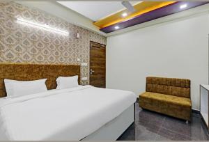 a bedroom with a bed and a chair at HOTEL AMAN in Allahābād