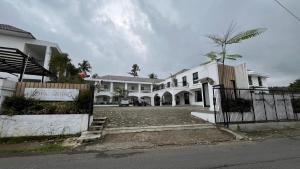 a large white house with a gate in front of it at The Royal Gisting - Heritage Hotel in Banjarnegeri