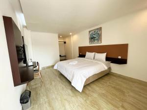 a bedroom with a large white bed in a room at The Royal Gisting - Heritage Hotel in Banjarnegeri