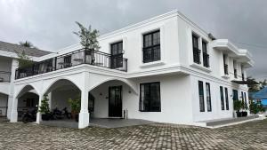 a white building with a balcony on top of it at The Royal Gisting - Heritage Hotel in Banjarnegeri