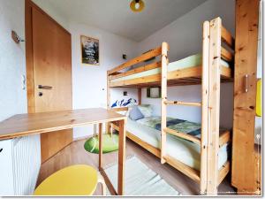 a room with bunk beds and a desk and a table at Fewo-Egger-Thalmann in Virgen
