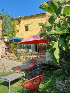 a patio with a table and chairs and an umbrella at Gîte les Granges dans ferme provençale. 14 pers in Ongles