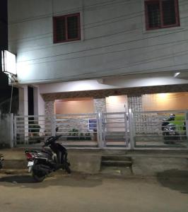 een motorfiets geparkeerd voor een huis 's nachts bij VRJ Residency inn in Chennai
