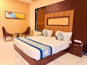 a bedroom with a large bed and two chairs at The Bhagwati Resort in Ābu Road +51 photos