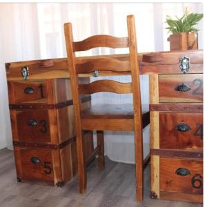 een houten bureau met een stoel naast een dressoir bij B&B MARIMA 2 POSTI ORGOSOLO in Orgosolo