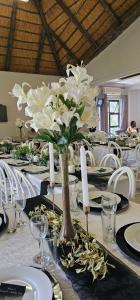 un tavolo con fiori bianchi in un vaso sopra di Phola La Bed and Breakfast a Melmoth