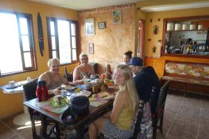 un grupo de personas sentadas alrededor de una mesa en un restaurante en Pousada Favelinha, en Río de Janeiro