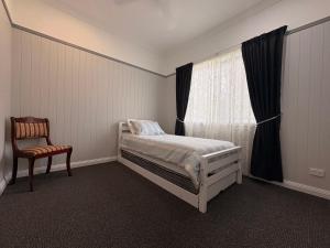 a bedroom with a bed and a chair and a window at Casa Tranquilo in Kanighan