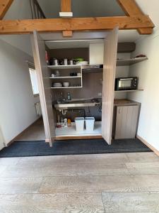 a kitchen in an attic with open shelves at Belle Nuit in Diksmuide +8 photos