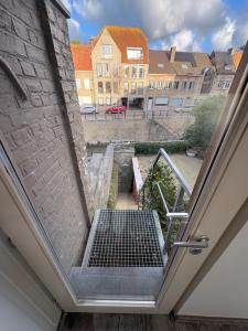an open door to a courtyard with buildings at Belle Nuit in Diksmuide