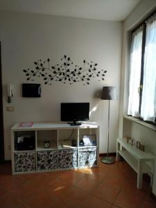 un soggiorno con TV e tavolo con lampada di La Dama di Fiori a Verolanuova