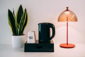 a table with a lamp and a cup and a plant at Borgo di Lazise - Adults friendly in Lazise