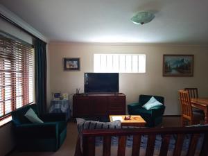 a living room with two chairs and a flat screen tv at Cosy Cottage in Sedgefield