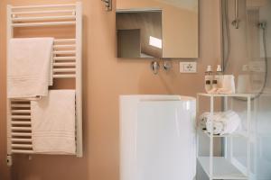 a bathroom with a white refrigerator and towels at Borgo di Lazise in Lazise