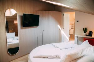 a bedroom with a white bed and a mirror at Borgo di Lazise in Lazise