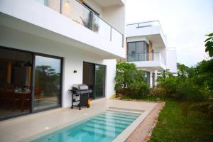 a house with a swimming pool next to a house at Bustani Villa in Mchamba Wima