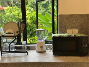 a kitchen counter with a blender and a microwave at The Urban Escape in Matara