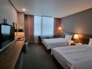 Postel nebo postele na pokoji v ubytování 퀸벨호텔