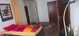 a bedroom with a bed with a colorful blanket and a mirror at Berg Messe 5, w-lan, Homeoffice in Bergisch Gladbach