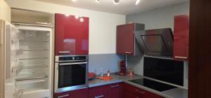 een keuken met rode kasten en een kookplaat oven bij Berg Messe 1, w-lan, Homeoffice in Bergisch Gladbach +19 foto's