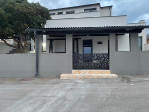 a white building with a sign on the front of it at Second home apartment - silver in Kustići