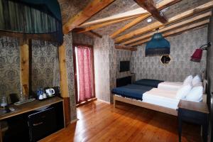 a bedroom with a bed in a room with wooden floors at Hotel Memoire Kutaisi in Kutaisi