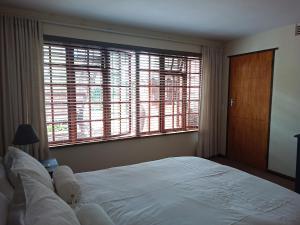 a bedroom with a large bed and large windows at Cosy Cottage in Sedgefield