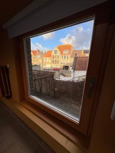 a window with a view of some buildings at Belle Nuit in Diksmuide