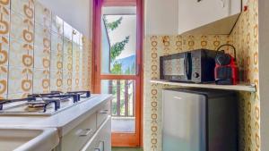 una cucina con fornelli, lavello e finestra di Accogliente appartamento a due minuti dal centro a Limone Piemonte