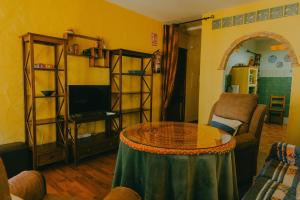 een woonkamer met een tafel en een tv bij La Huella del Cuero in Siles