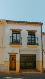 een wit gebouw met twee deuren en twee ramen bij La Huella del Cuero in Siles