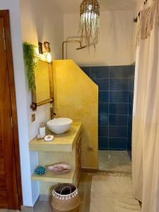 een badkamer met een wastafel en een spiegel bij Téranga paradis in Somone