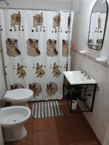 a bathroom with a shower curtain with a toilet and a sink at Forza e avanti in Santa Teresita